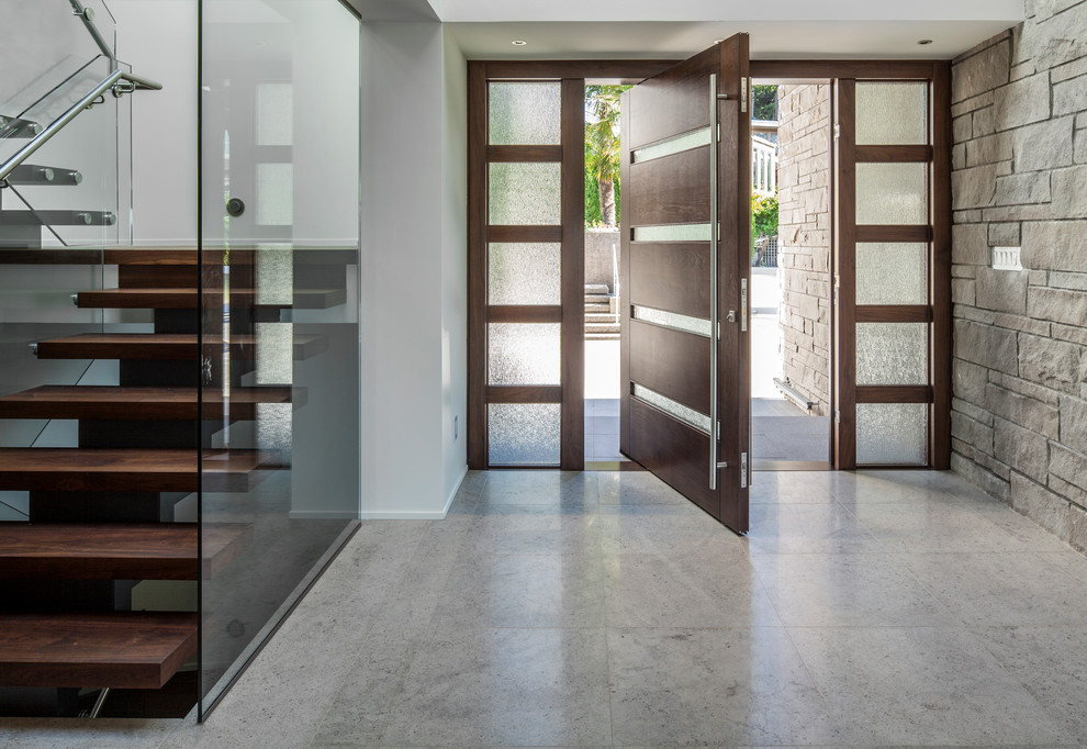 Photo of a contemporary entrance in Vancouver with a pivot front door and grey floors.