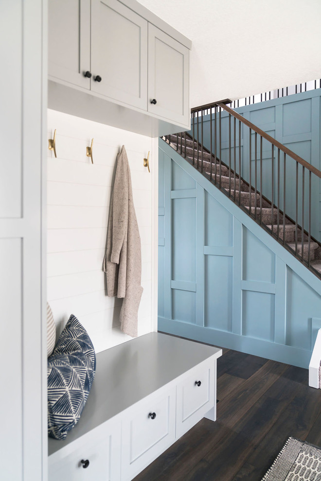 Inspiration pour une entrée traditionnelle de taille moyenne avec un vestiaire, un mur bleu, parquet foncé et un sol marron.