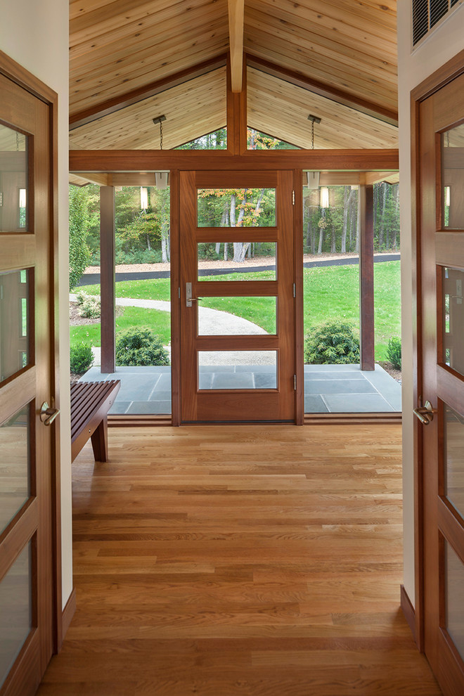 Inspiration pour un hall d'entrée vintage de taille moyenne avec un mur blanc, un sol en bois brun, une porte simple et une porte en verre.
