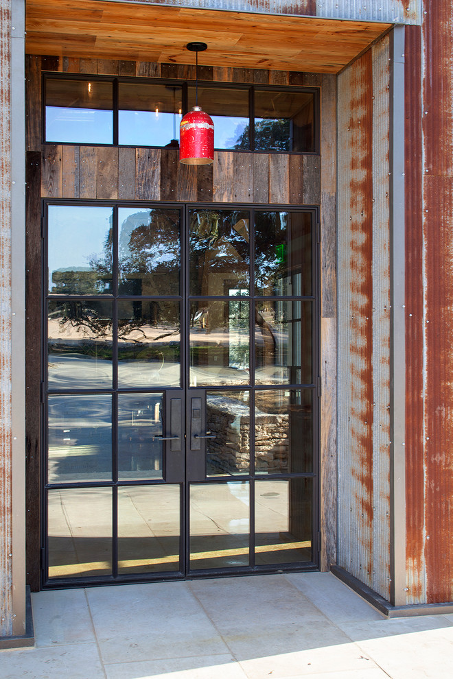 Immagine di una porta d'ingresso stile rurale con una porta a due ante e una porta in metallo