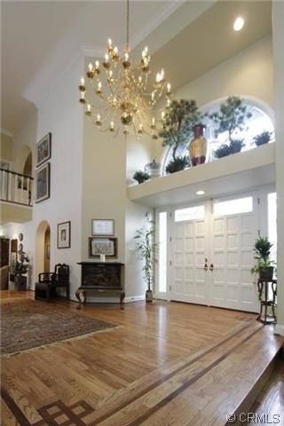 Mittelgroßes Klassisches Foyer mit weißer Wandfarbe, braunem Holzboden, Doppeltür und weißer Haustür in Los Angeles