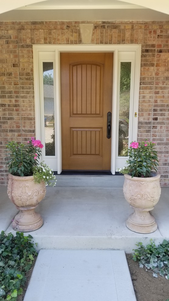 Ispirazione per una porta d'ingresso chic di medie dimensioni con una porta singola e una porta in legno bruno