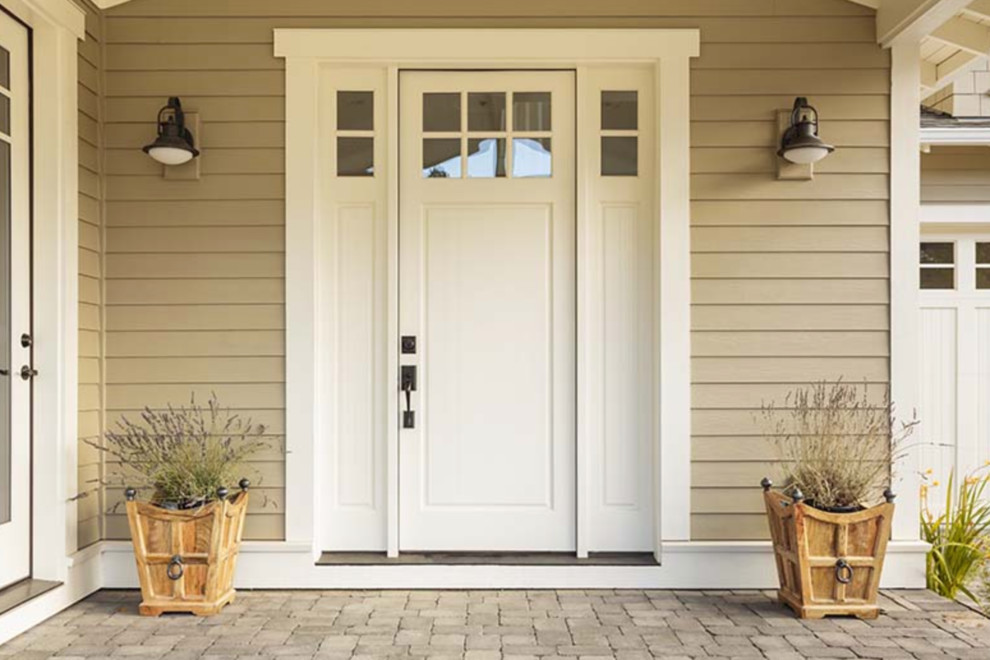 На фото: прихожая среднего размера в стиле неоклассика (современная классика) с бежевыми стенами, кирпичным полом, одностворчатой входной дверью, белой входной дверью и коричневым полом