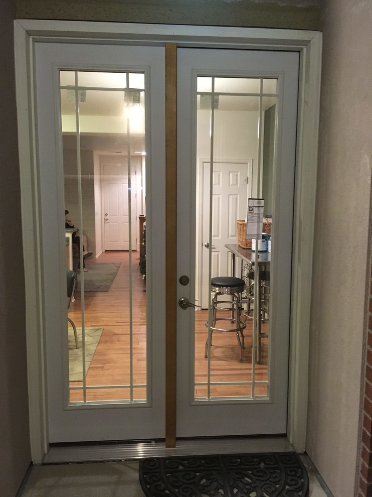 Cette photo montre une petite entrée tendance avec une porte double et une porte en verre.