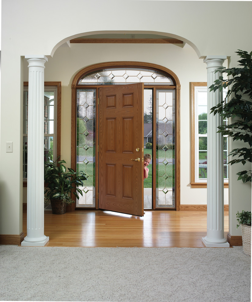 Klassische Haustür mit weißer Wandfarbe, hellem Holzboden, Einzeltür und hellbrauner Holzhaustür in Milwaukee