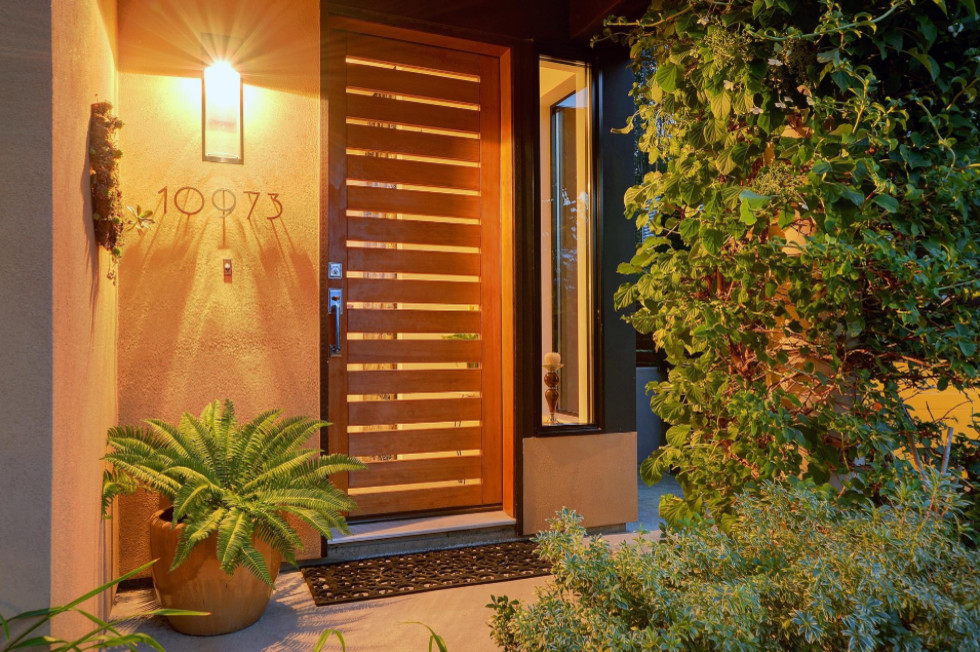 Modelo de puerta principal minimalista grande con paredes beige, puerta simple y puerta de madera en tonos medios