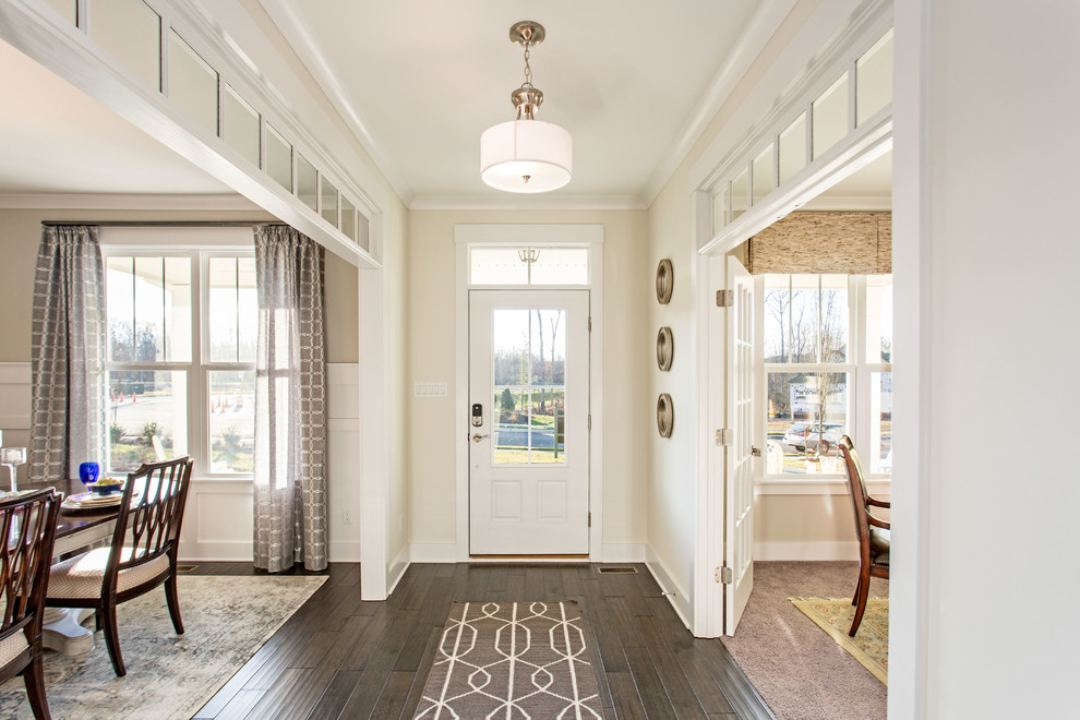 Example of a beach style dark wood floor entryway design in Richmond with beige walls and a white front door