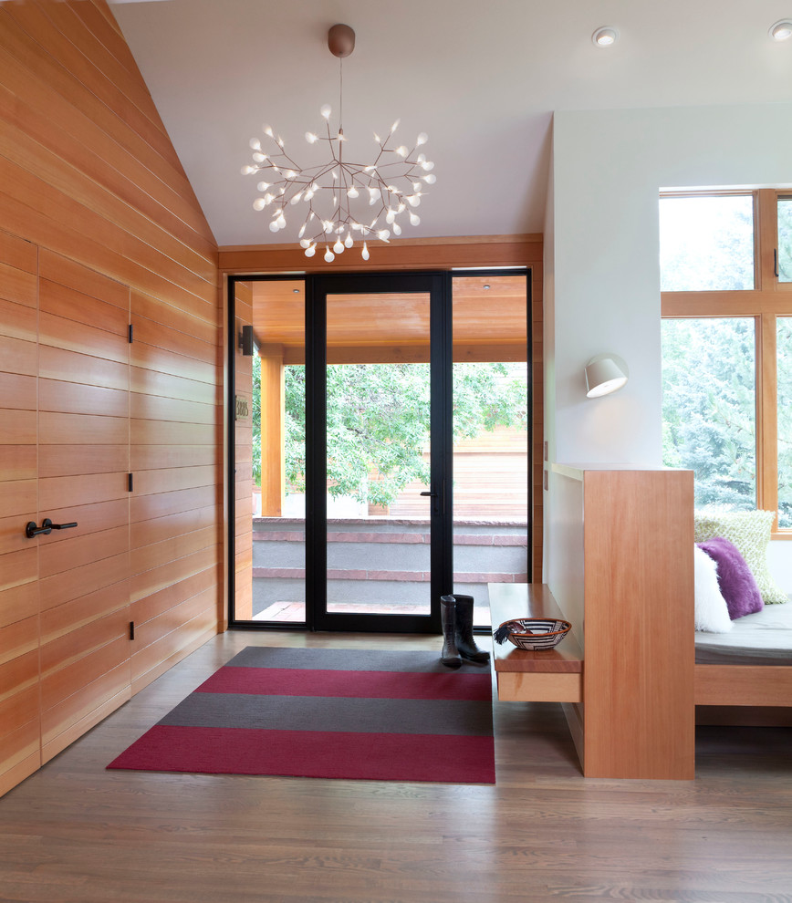 Modelo de puerta principal actual de tamaño medio con paredes blancas, suelo de madera en tonos medios, puerta simple, puerta de vidrio y suelo marrón