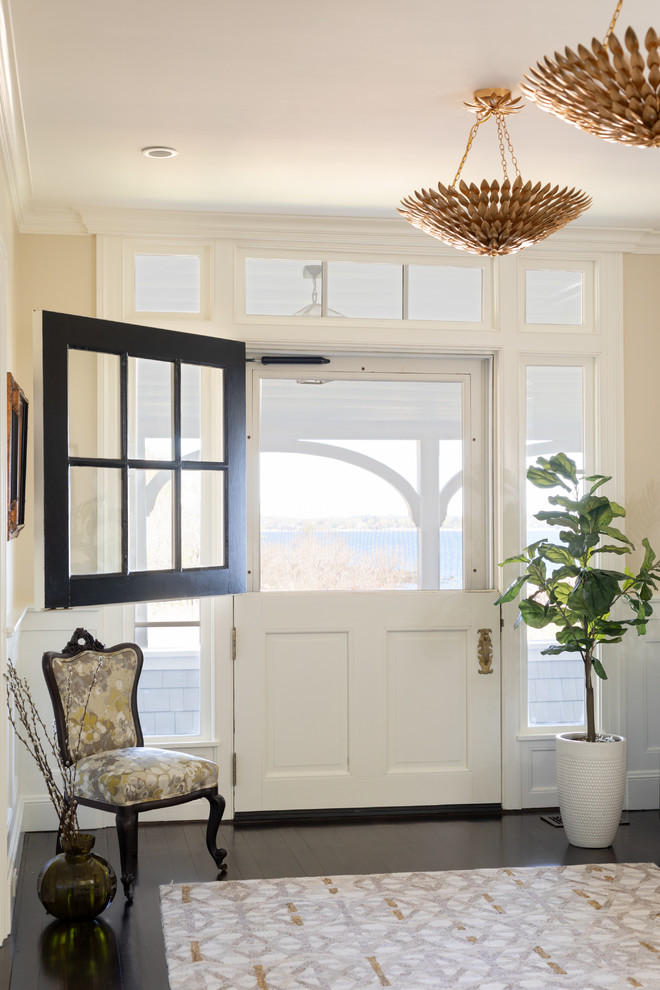 Maritime Haustür mit Klöntür, beiger Wandfarbe, dunklem Holzboden und weißer Haustür in Boston