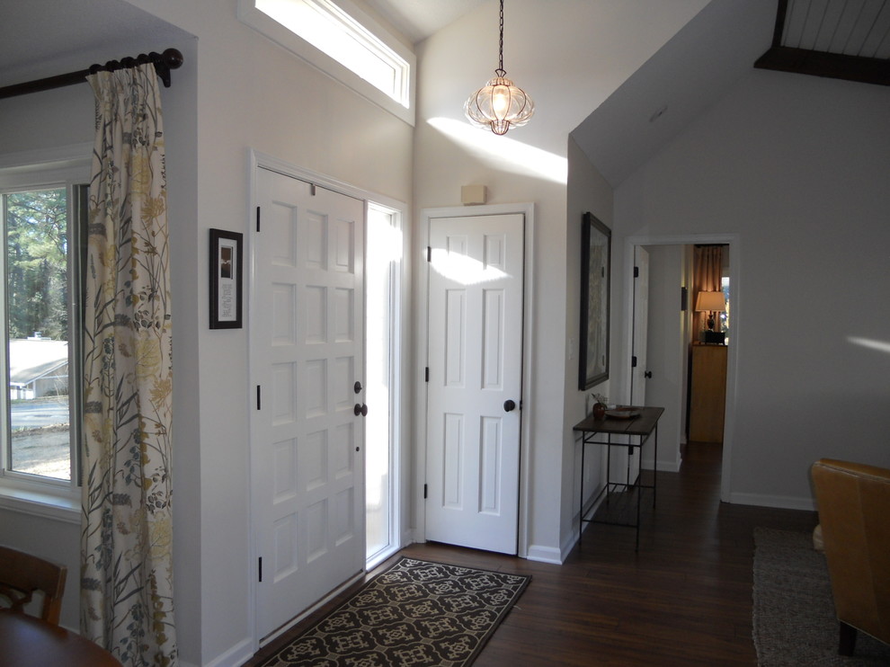 Стильный дизайн: маленькая входная дверь в стиле неоклассика (современная классика) с белыми стенами, темным паркетным полом, одностворчатой входной дверью и белой входной дверью для на участке и в саду - последний тренд