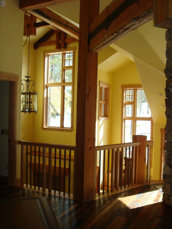 Immagine di un ingresso stile rurale di medie dimensioni con pareti gialle, pavimento in legno massello medio e una porta in legno bruno