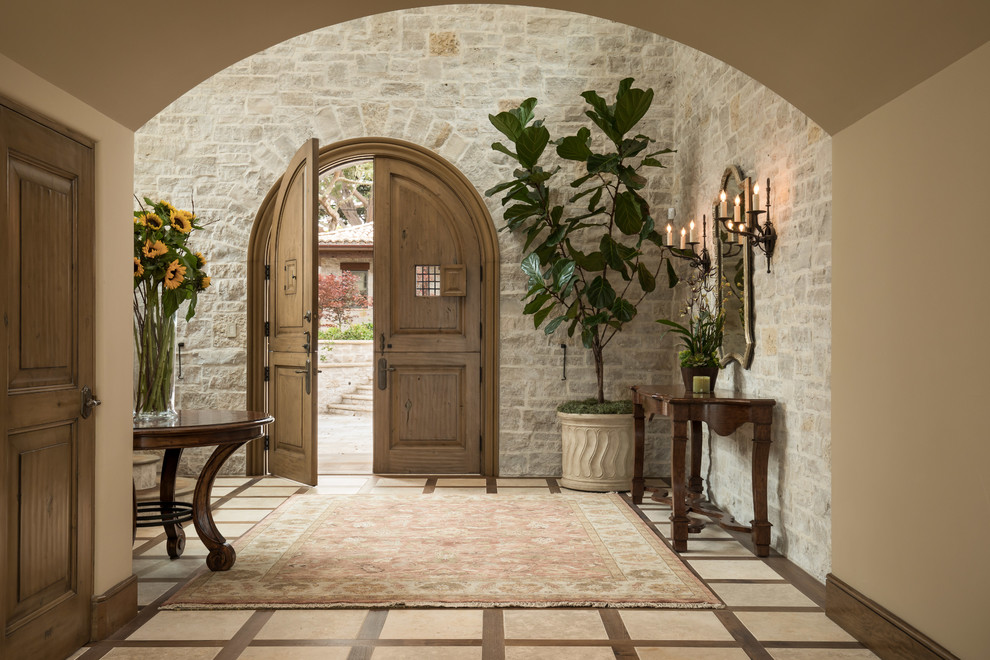 Свежая идея для дизайна: большое фойе в средиземноморском стиле с бежевыми стенами, полом из керамической плитки, двустворчатой входной дверью, коричневой входной дверью и бежевым полом - отличное фото интерьера