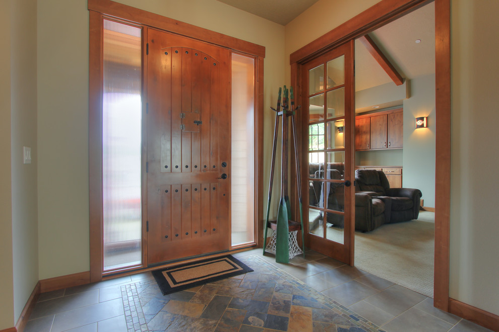 Idee per un ingresso tradizionale di medie dimensioni con pavimento in ardesia, una porta singola, pareti beige, una porta in legno bruno e pavimento multicolore