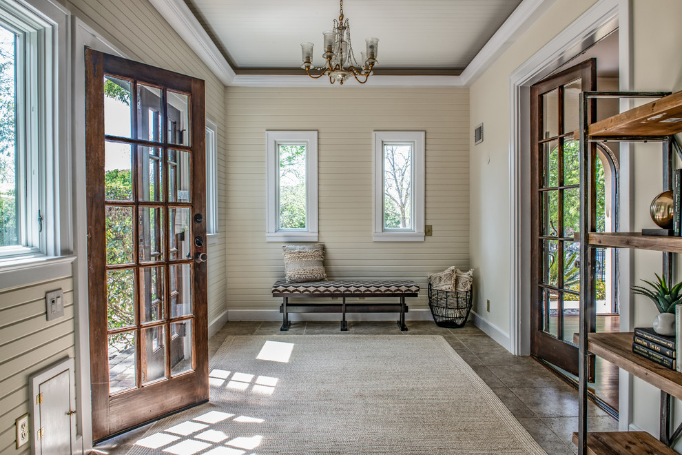 Klassischer Eingang mit beiger Wandfarbe, Doppeltür, Haustür aus Glas und grauem Boden in Austin