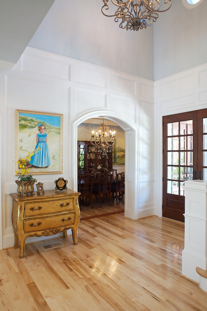 Inspiration for a timeless light wood floor foyer remodel in Charlotte with white walls