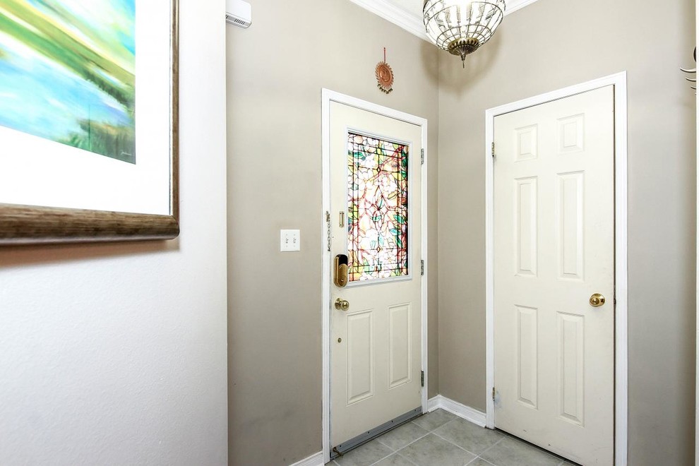 Cette photo montre une petite porte d'entrée chic avec un mur beige, un sol en carrelage de céramique, une porte simple et une porte blanche.