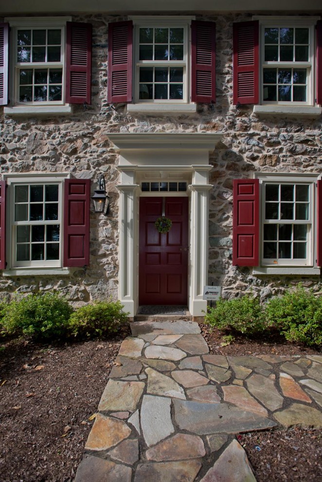 Country entryway photo in Philadelphia with multicolored walls and a red front door