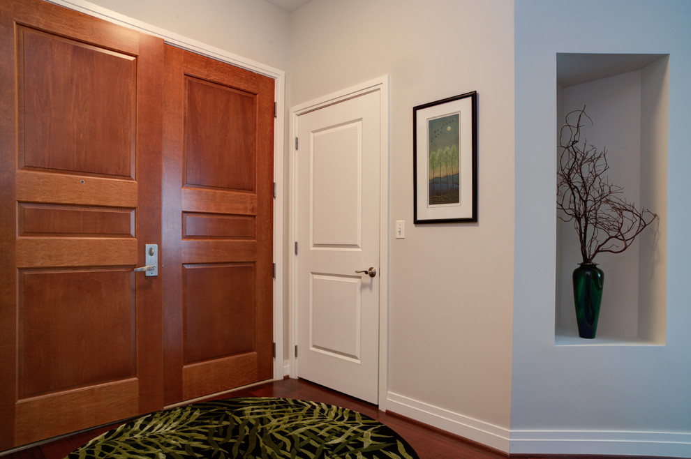 Foto de puerta principal tradicional renovada pequeña con paredes blancas, suelo de madera oscura y puerta de madera en tonos medios