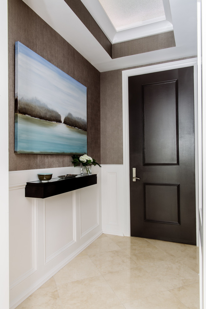 ワシントンD.C.にあるラグジュアリーな小さなコンテンポラリースタイルのおしゃれな玄関ロビー (ベージュの壁、大理石の床、濃色木目調のドア) の写真