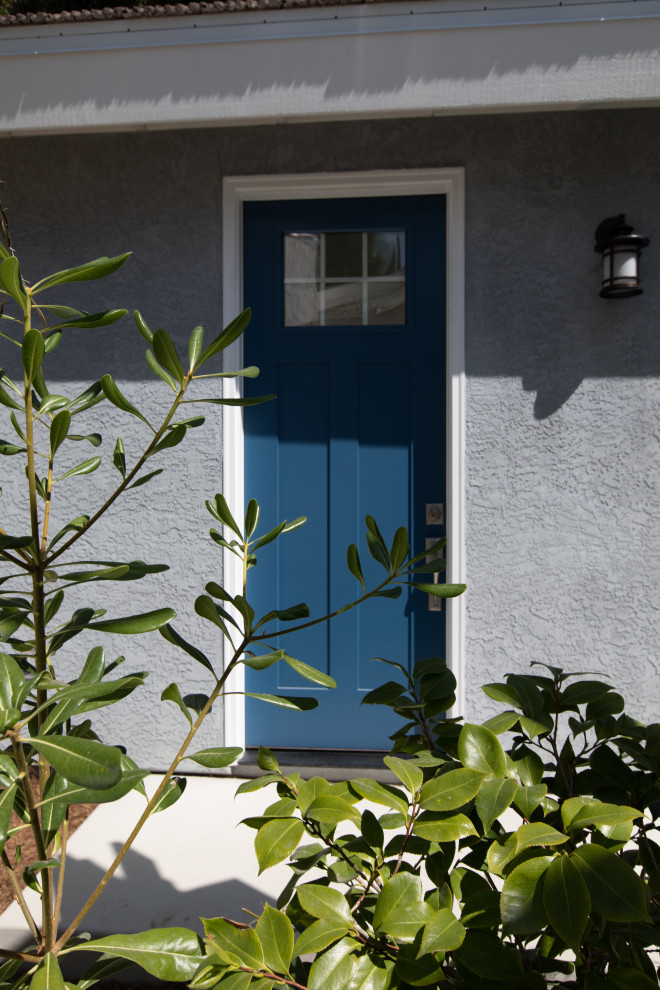 This is an example of a small front door in San Diego with grey walls, concrete flooring, a single front door and a blue front door.