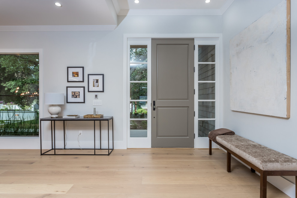 Ejemplo de distribuidor clásico renovado extra grande con paredes blancas, suelo de madera clara, puerta simple, puerta gris, suelo beige y bandeja