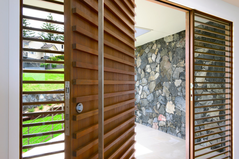 Bild på en mellanstor funkis ingång och ytterdörr, med grå väggar, mellanmörkt trägolv, en enkeldörr och mellanmörk trädörr