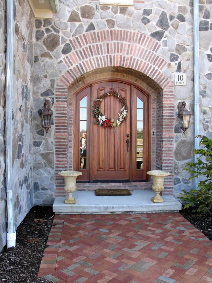 Foto på en medelhavsstil ingång och ytterdörr, med en enkeldörr och mellanmörk trädörr