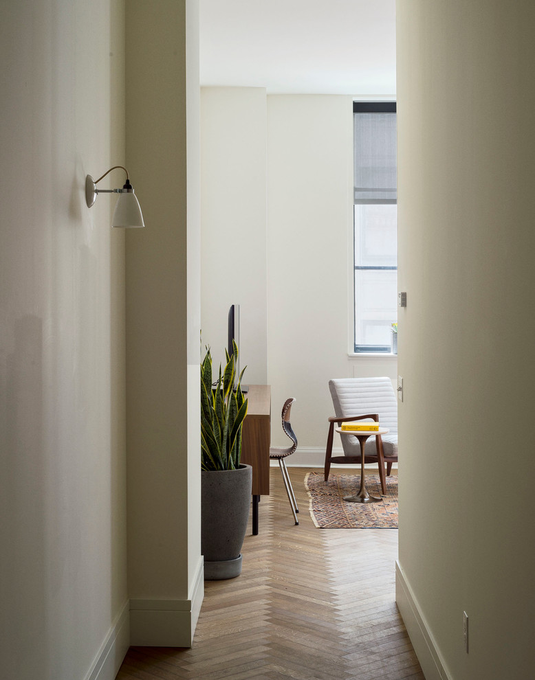 Aménagement d'une petite entrée classique avec un couloir, un mur beige et un sol en bois brun.