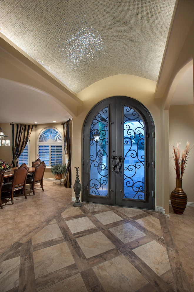 Inspiration pour un grand hall d'entrée méditerranéen avec une porte double, un mur beige, un sol en travertin et une porte en verre.
