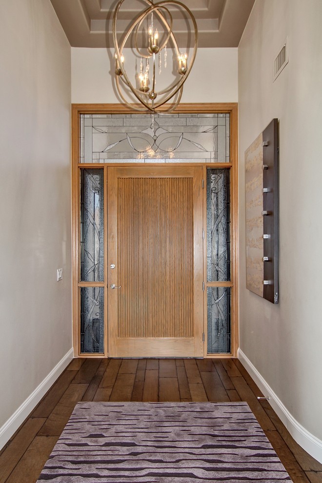 Ejemplo de hall contemporáneo de tamaño medio con paredes grises, suelo de madera en tonos medios, puerta simple y puerta de madera clara