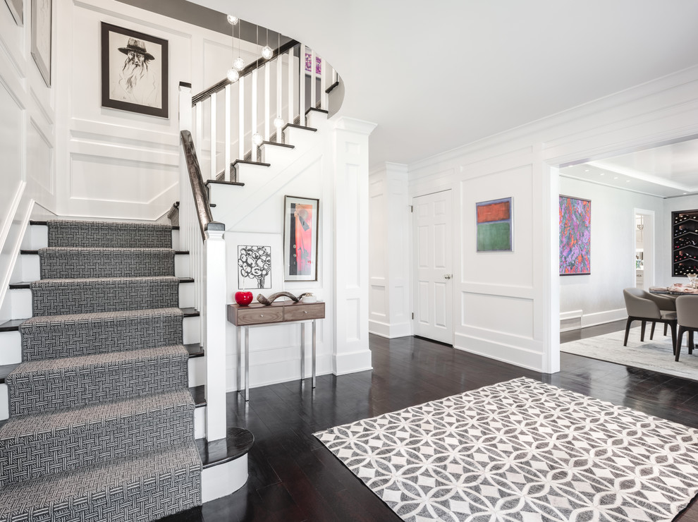 Mittelgroßes Klassisches Foyer mit weißer Wandfarbe, dunklem Holzboden, Einzeltür, hellbrauner Holzhaustür und braunem Boden in New York