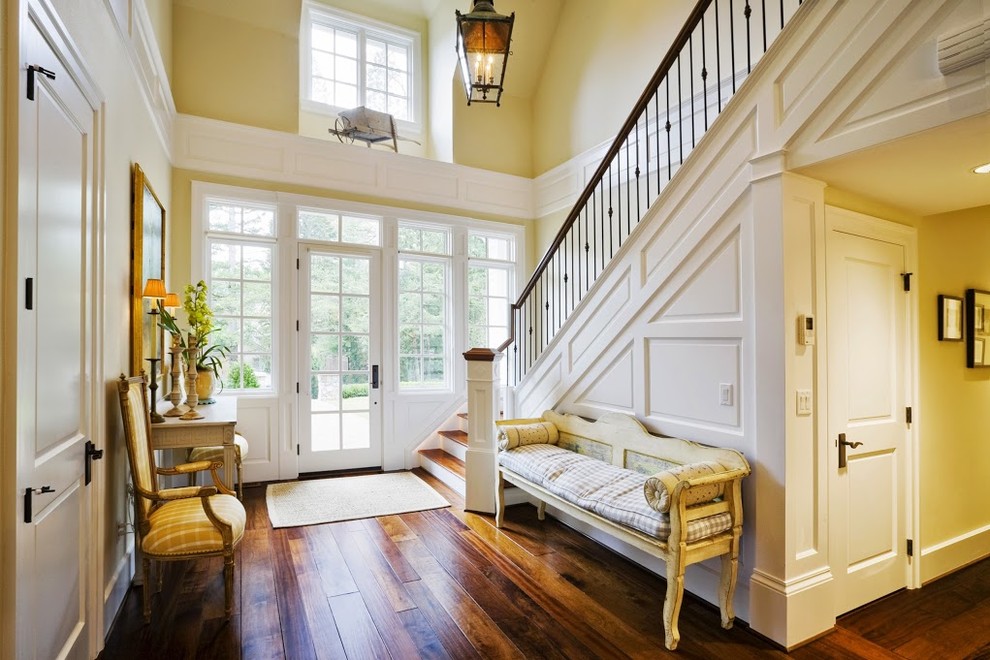 Inspiration for a large timeless medium tone wood floor and brown floor entryway remodel in Charlotte with beige walls and a glass front door