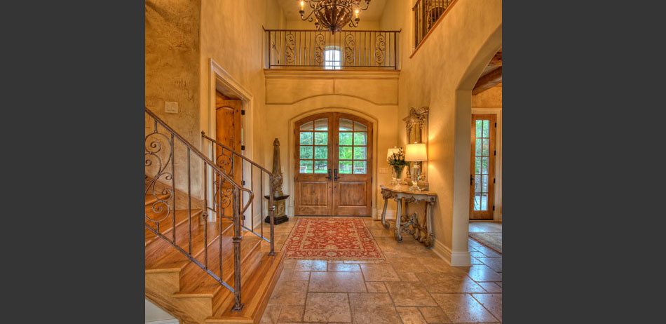 Mid-sized tuscan travertine floor and brown floor entryway photo in Other with brown walls and a dark wood front door