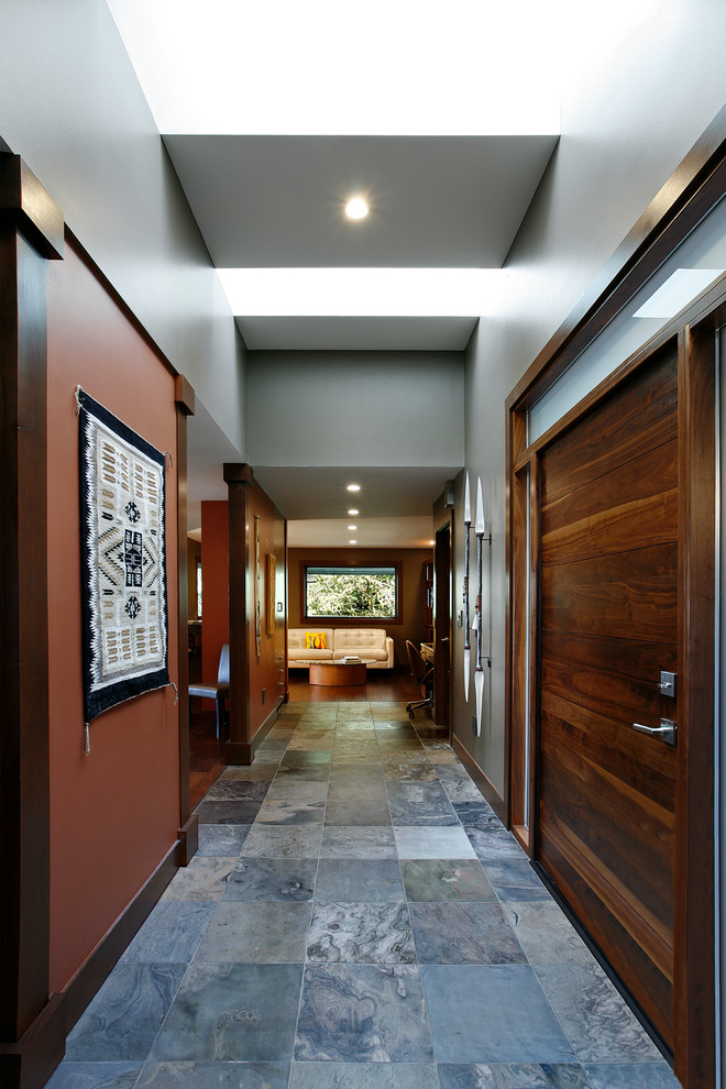 Diseño de puerta principal tradicional renovada de tamaño medio con paredes grises, suelo de pizarra, puerta pivotante y puerta de madera en tonos medios