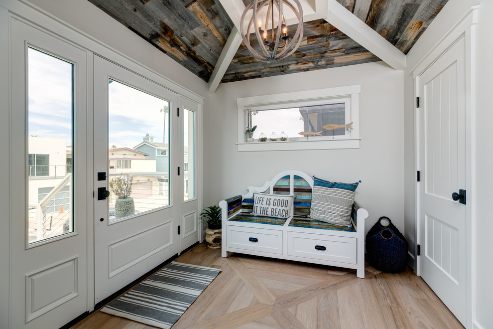 Mid-sized beach style beige floor and light wood floor entryway photo in Los Angeles with white walls and a white front door