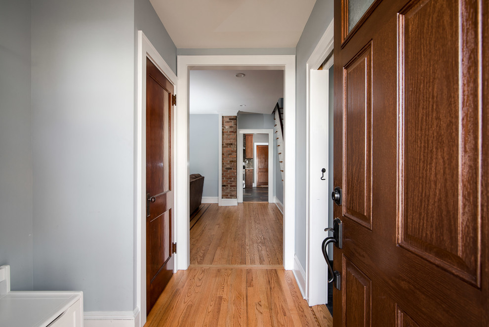 Diseño de vestíbulo clásico renovado pequeño con paredes azules, suelo de madera en tonos medios, puerta simple, puerta de madera en tonos medios y suelo marrón