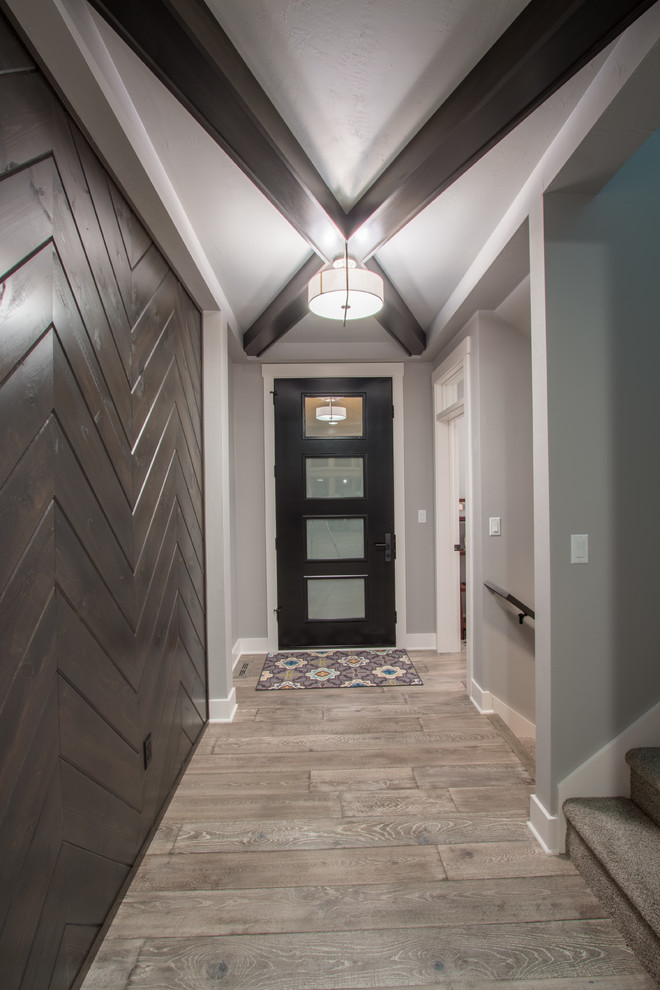 Mittelgroßes Landhaus Foyer mit grauer Wandfarbe, braunem Holzboden, Einzeltür, schwarzer Haustür und grauem Boden in Milwaukee