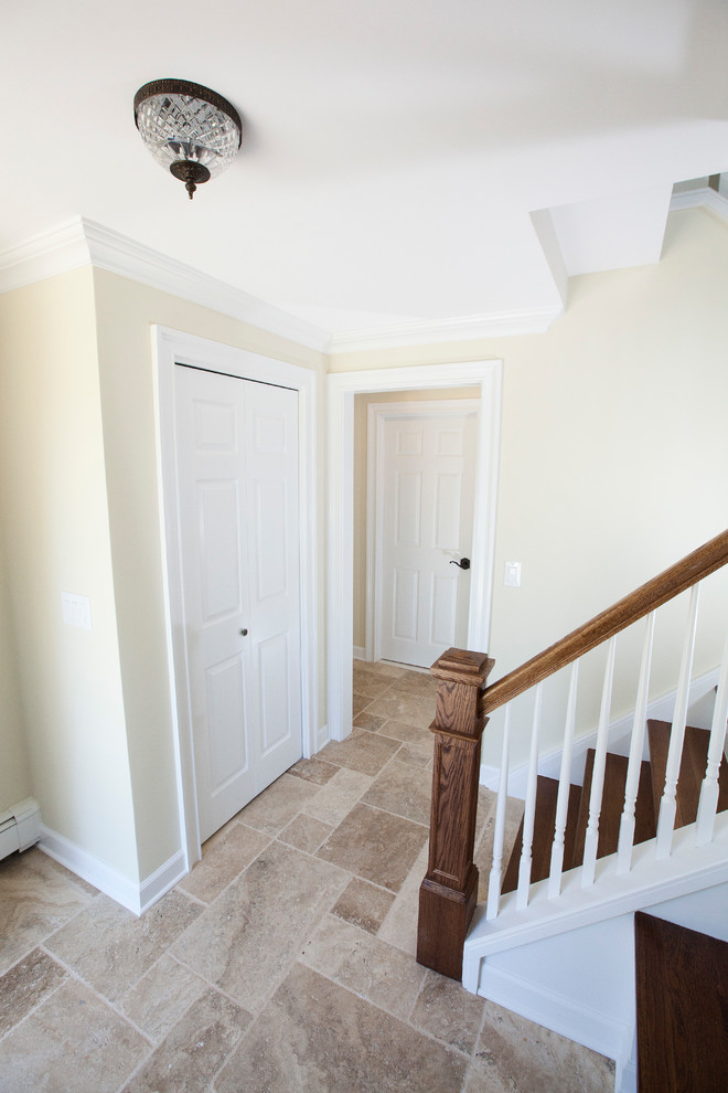 Small elegant slate floor entryway photo in New York with beige walls and a brown front door