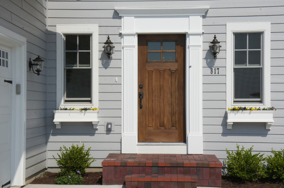 Design ideas for a small traditional front door in Other with grey walls, a single front door and a medium wood front door.