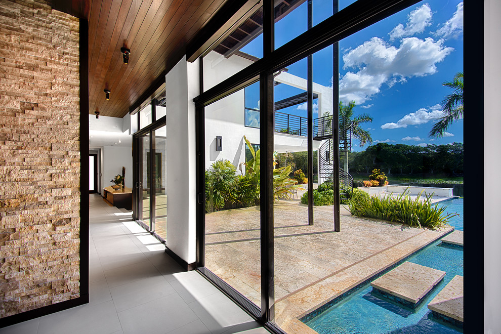 Cette image montre un hall d'entrée design avec un sol en carrelage de porcelaine, une porte simple et une porte en verre.