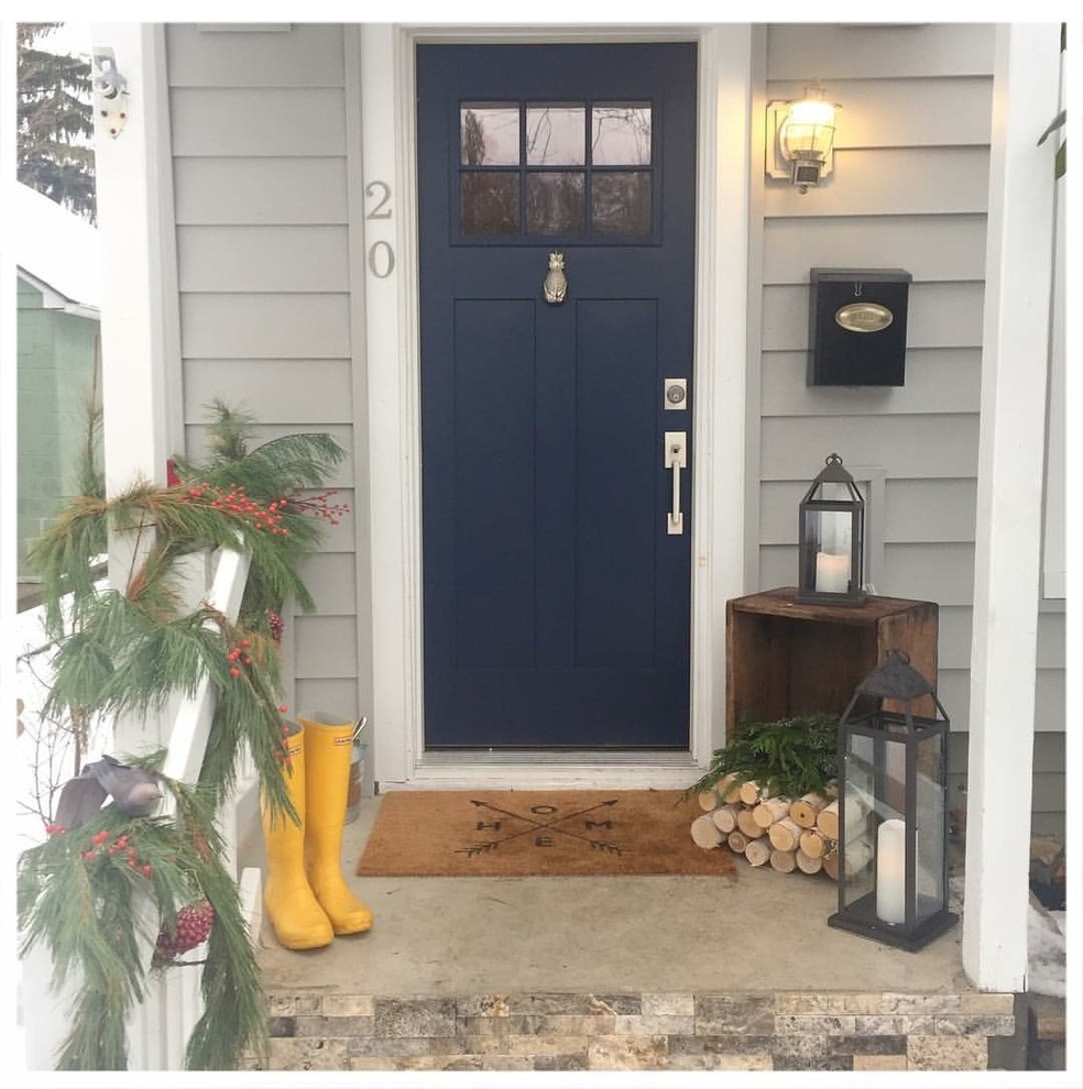 Lantlig inredning av en entré, med en enkeldörr och en blå dörr