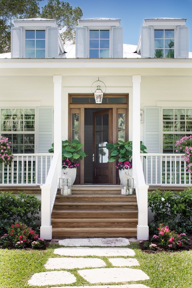 Inspiration for a mid-sized coastal medium tone wood floor and brown floor single front door remodel in New Orleans with white walls and a medium wood front door