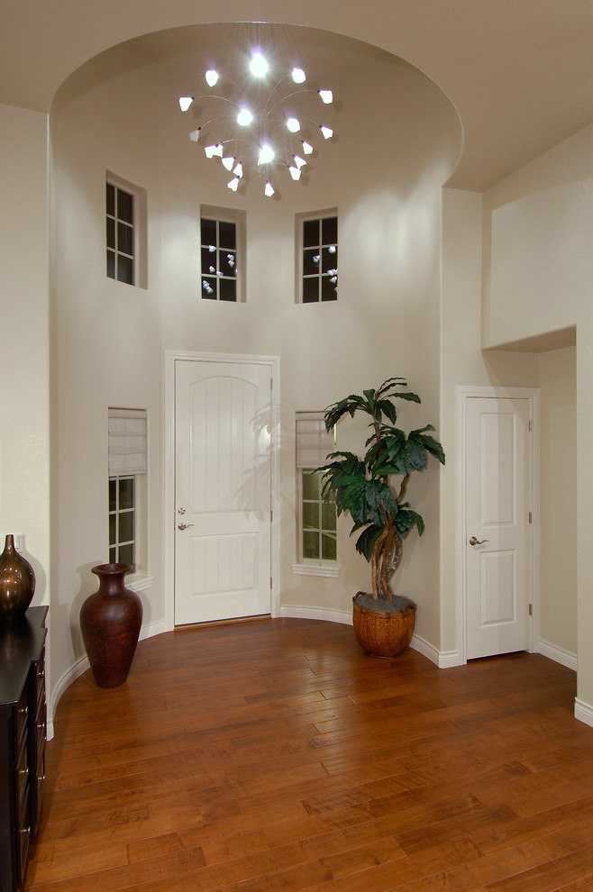 Mid-sized trendy medium tone wood floor entryway photo in Denver with white walls and a white front door