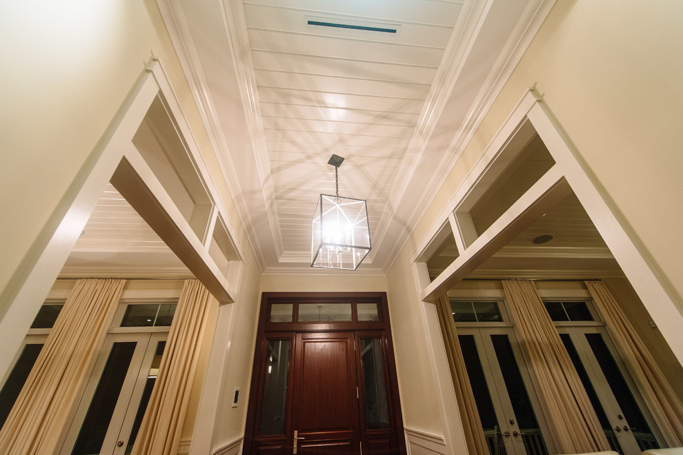 Foto de hall clásico renovado de tamaño medio con paredes blancas, suelo de madera en tonos medios, puerta simple, puerta de madera oscura y suelo beige