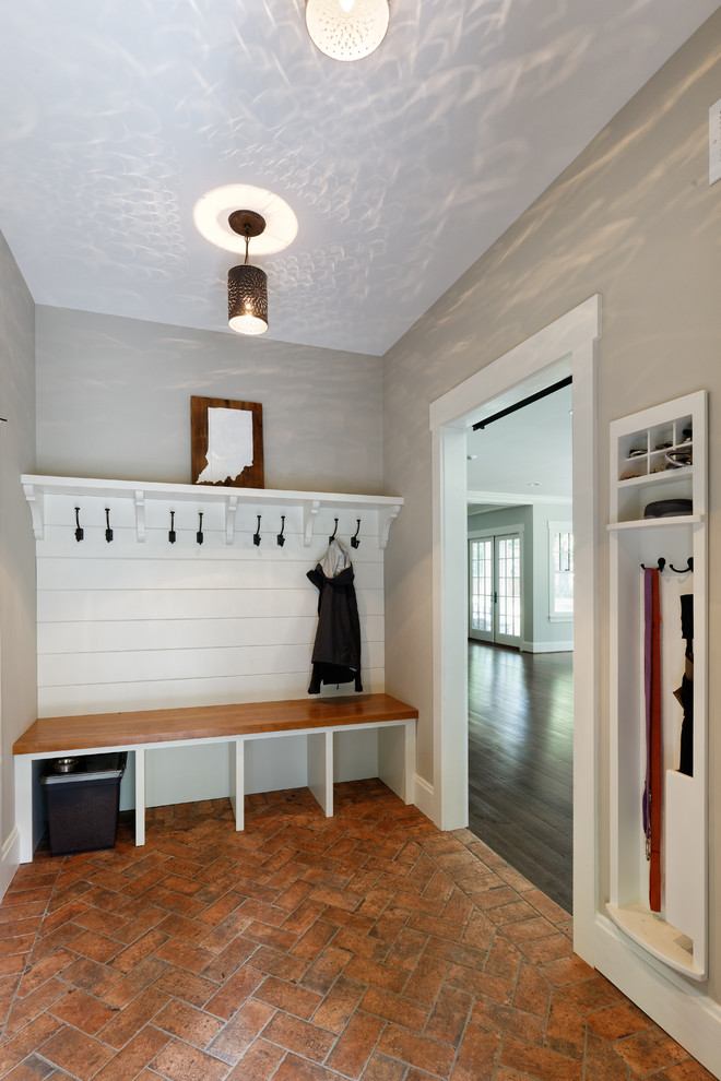 Photo of a medium sized classic boot room in Cincinnati with grey walls, brick flooring and red floors.