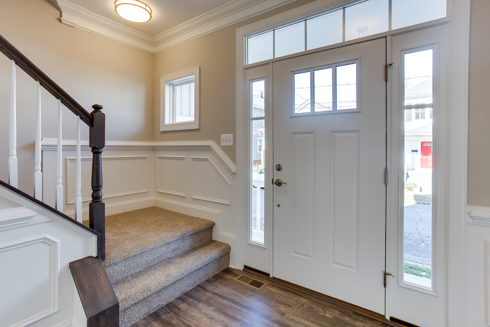 Свежая идея для дизайна: входная дверь среднего размера в стиле неоклассика (современная классика) с бежевыми стенами, полом из ламината, поворотной входной дверью, белой входной дверью и коричневым полом - отличное фото интерьера