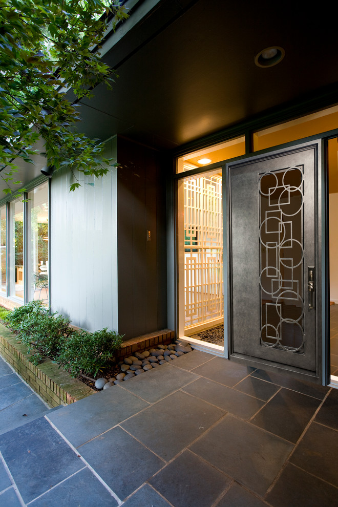 Idée de décoration pour une porte d'entrée minimaliste de taille moyenne avec un sol en ardoise, une porte métallisée, un mur marron et une porte simple.