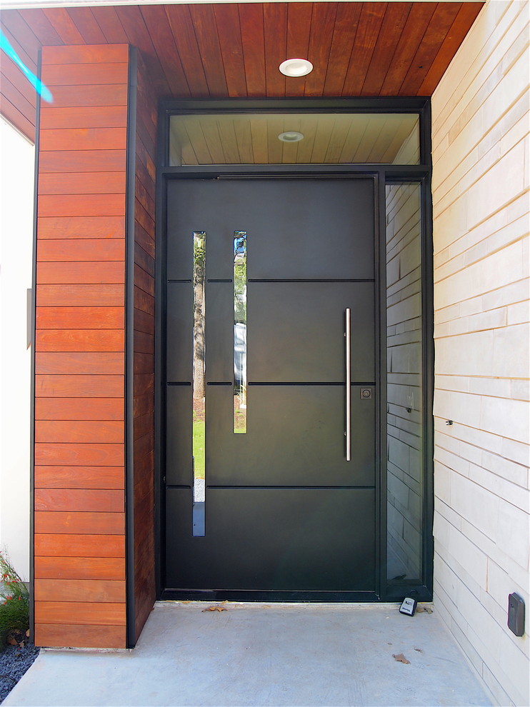 Réalisation d'une porte d'entrée design de taille moyenne avec un mur marron, sol en béton ciré, une porte pivot et une porte noire.