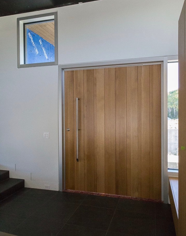 他の地域にあるラグジュアリーな巨大なコンテンポラリースタイルのおしゃれな玄関ドア (淡色木目調のドア) の写真