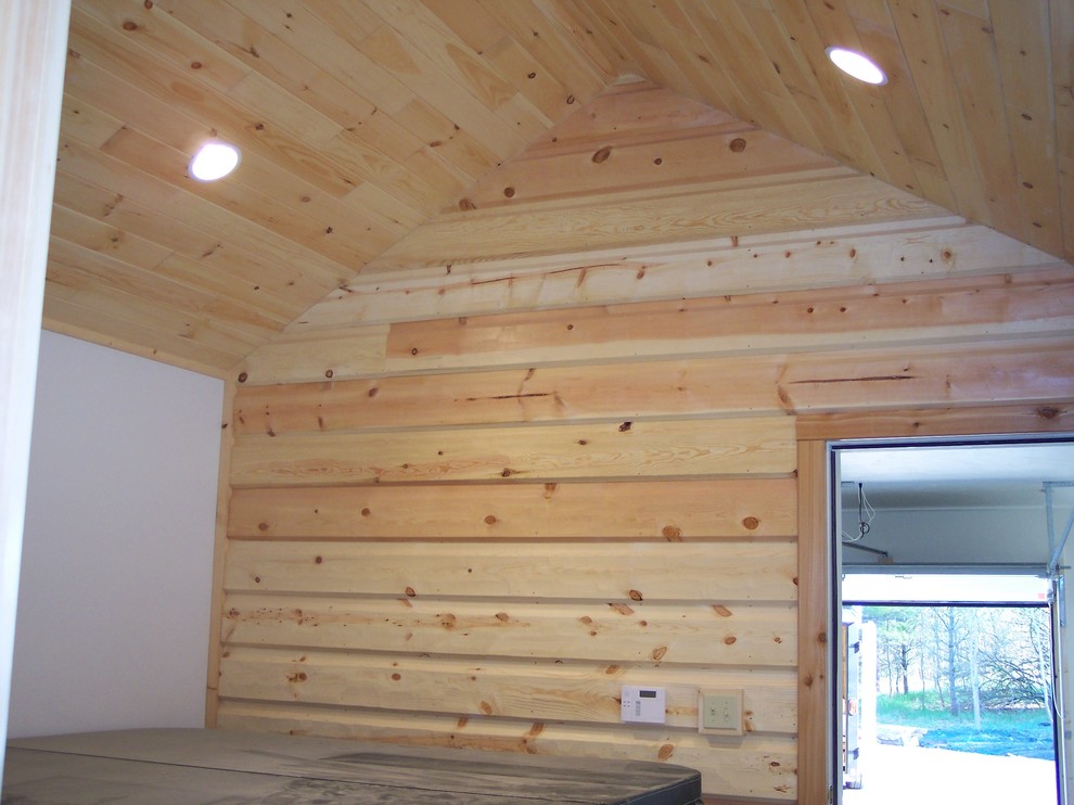 Cette image montre une entrée nordique en bois de taille moyenne avec un vestiaire, un mur beige et un plafond en bois.
